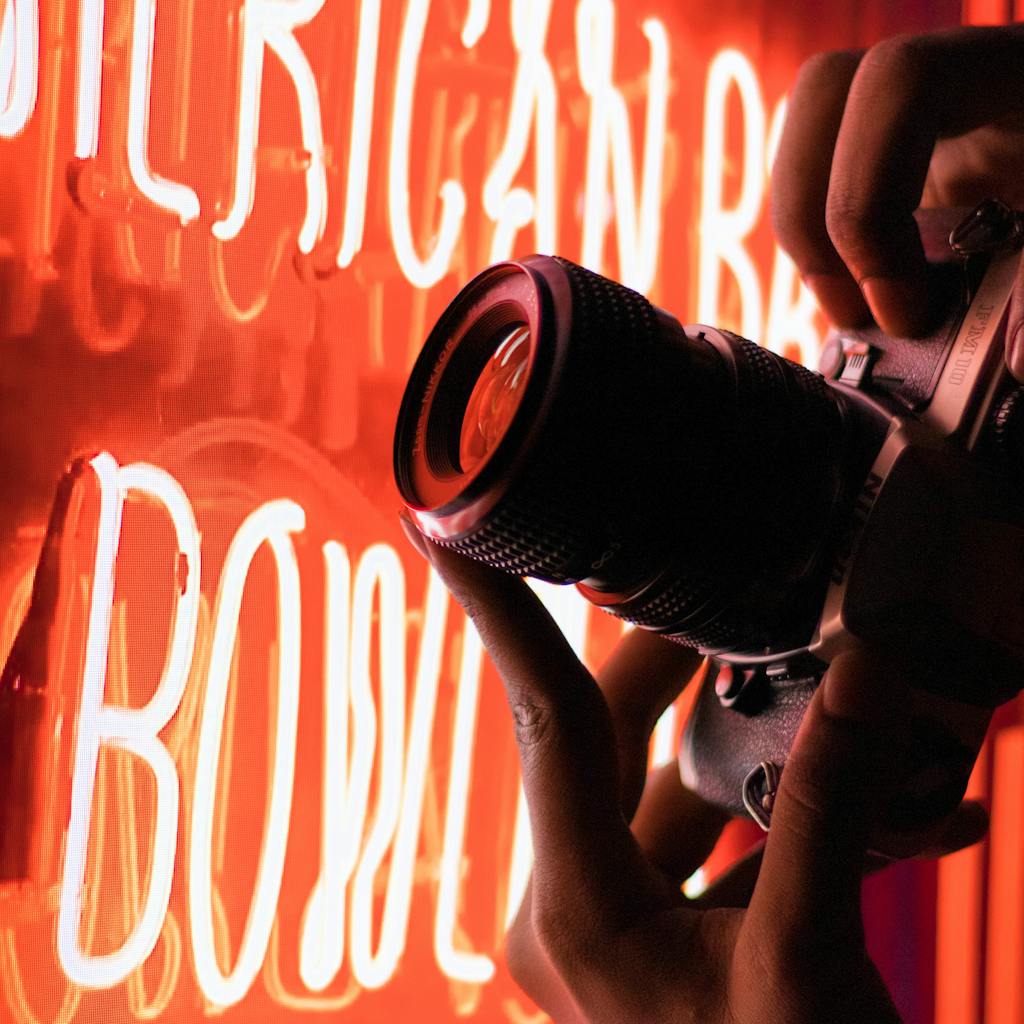 Capturing neon sign with camera up-close. Vibrant and creative lighting.